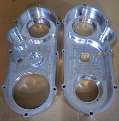 Getriebekasten Zwei präzise bearbeitete Aluminiumteile mit verschiedenen Öffnungen und Vertiefungen.