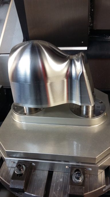 3D Aluminium Bauteil Vorne eine glänzende, metallene Form, die eine gerundete Oberfläche zeigt.