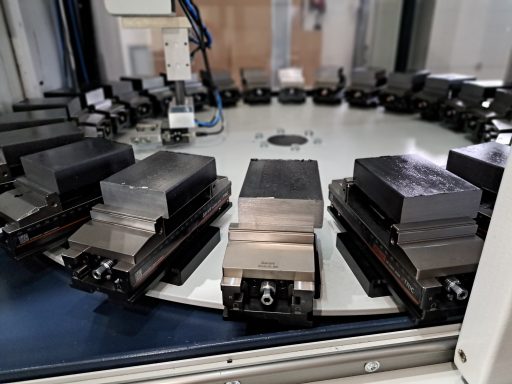 Serienfertigung Industrielle Maschinenkomponenten auf einem runden Tisch mit mehreren Halterungen.